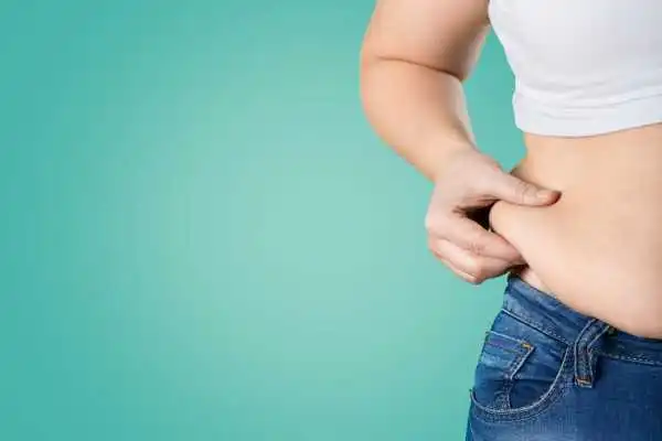 Image of woman pinching her love handles to show weight gain Dysart